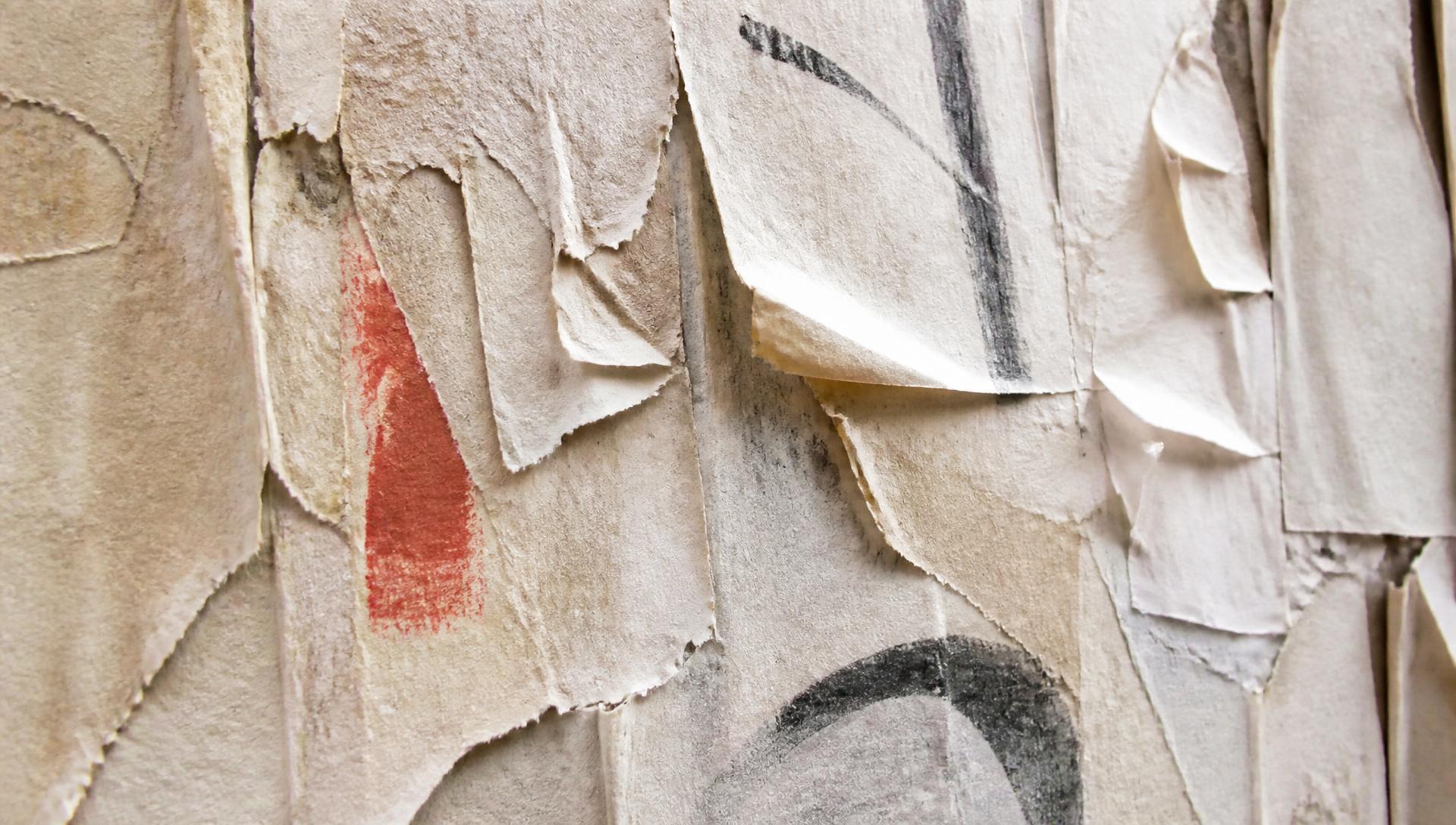 Torn wheat-pasted paper layers on a New York wall, edges lifting in the light